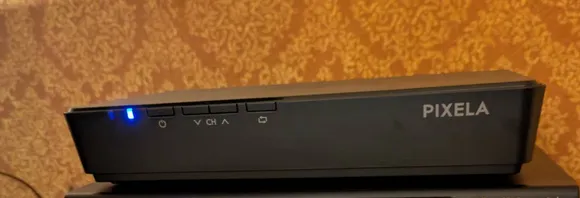 テレビの横に置かれた機械。青いランプが点いています