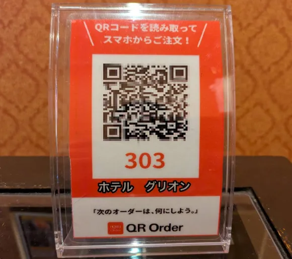 客室のテーブルに置かれた、スマホからご注文いただくためのQRコードの立て札